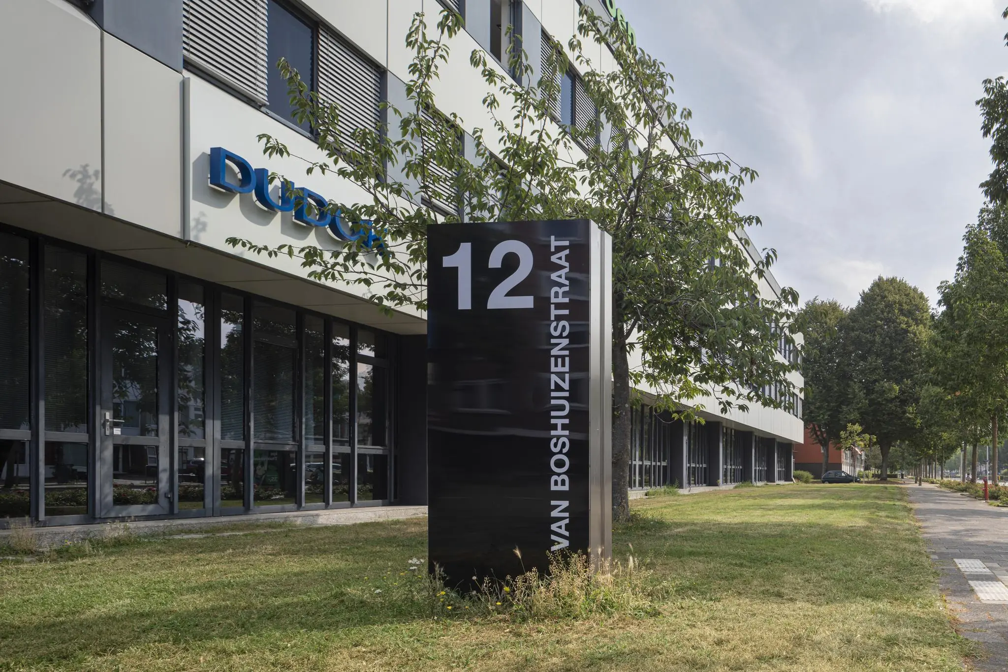 Kantoorgebouw aan de Van Boshuizenstraat 12 met bedrijfsnaam Dudok zichtbaar op de gevel.